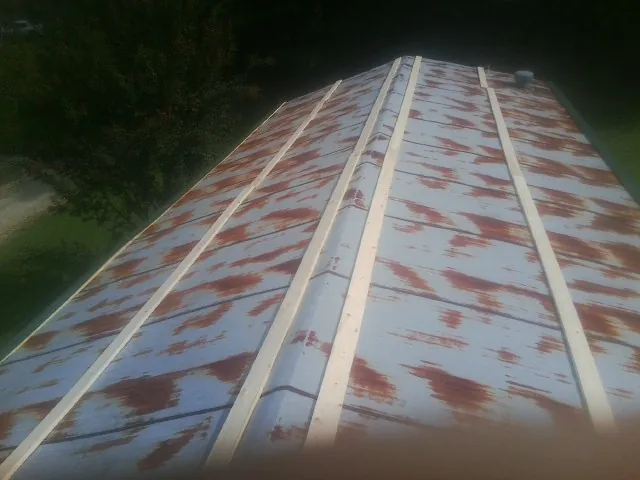 Rusted metal roof panels with new wood purlins before replacement — Storm Damage Roof Repair in Lytle Creek by Roofing Brothers