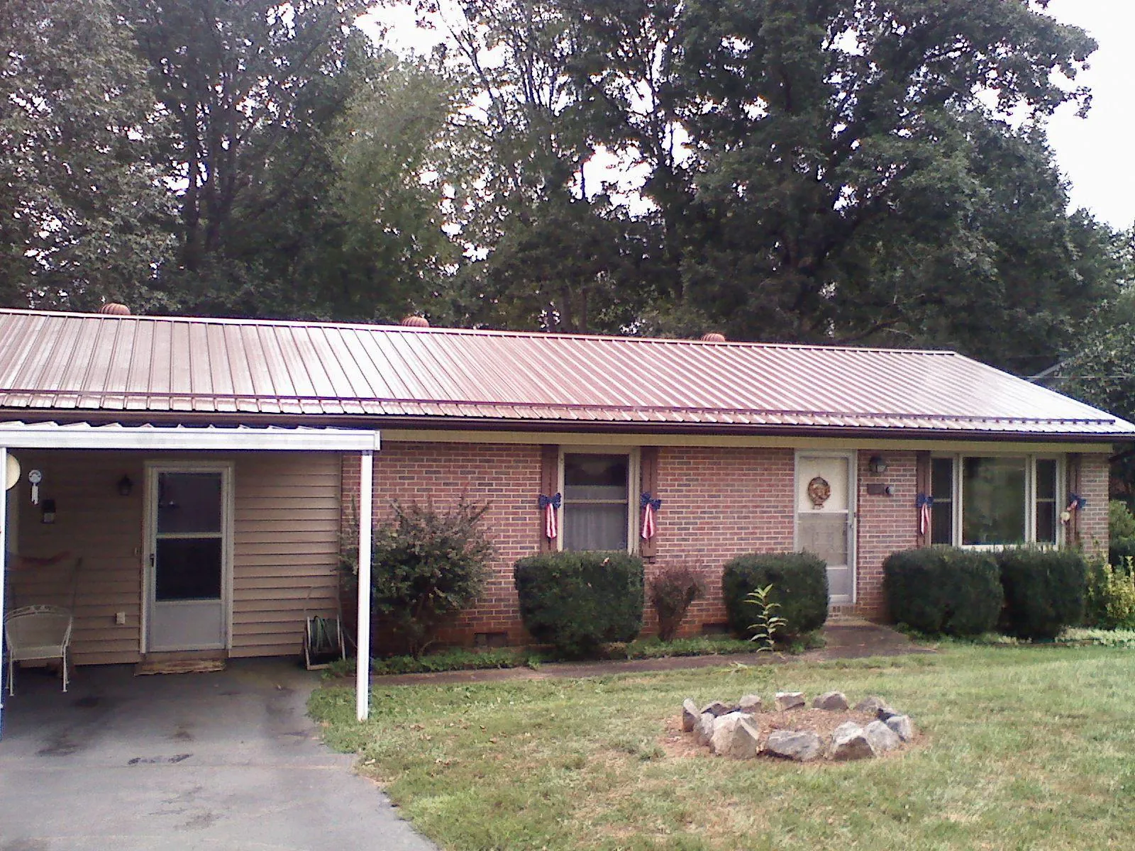 Bronze metal roof and carport on a brick ranch home — Roof Repair work by our crew in Lytle Creek