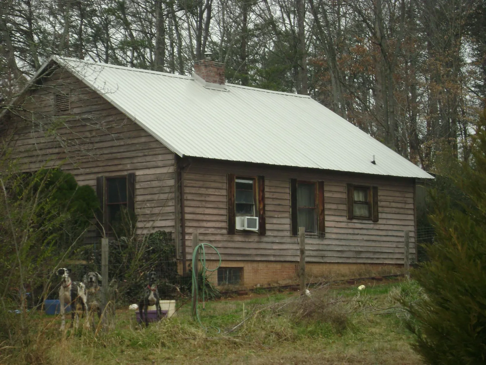 White metal roof on an old wood sided farmhouse, from a Metal Roof Installation job in Lytle Creek